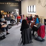 Our Freedom Workshop at Kirkgate Arts and Heritage A group of people in the Kirkgate Centre's Egremont room. they're sitting on chairs in a circle listening to one of the group talking